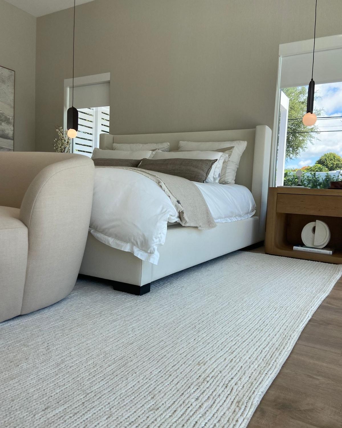 Modern primary bedroom with linen finishes and pendant lighting