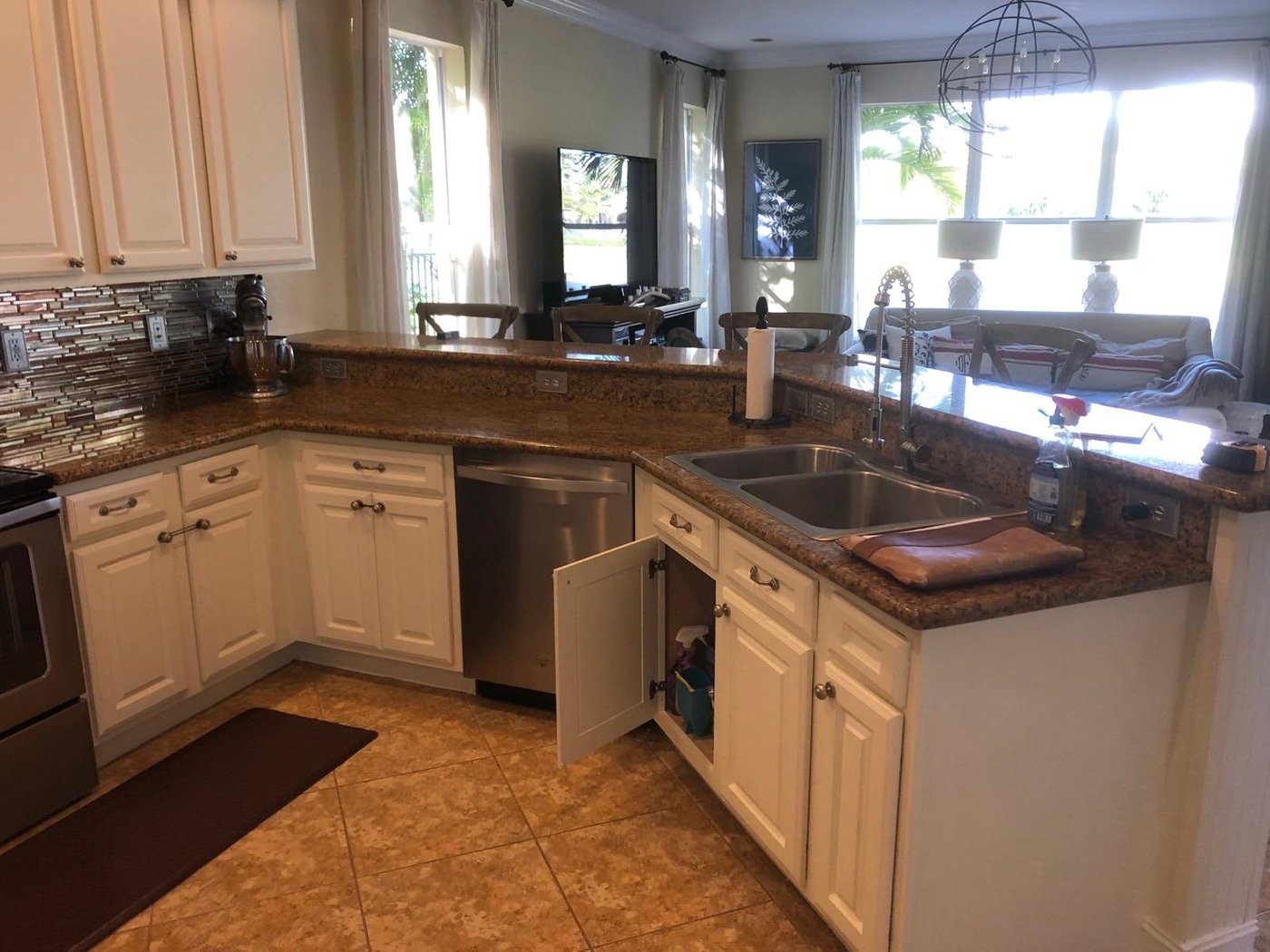 The original kitchen with dark brown cabinetry, granite countertops, and the corner pantry interrupting the counter run
