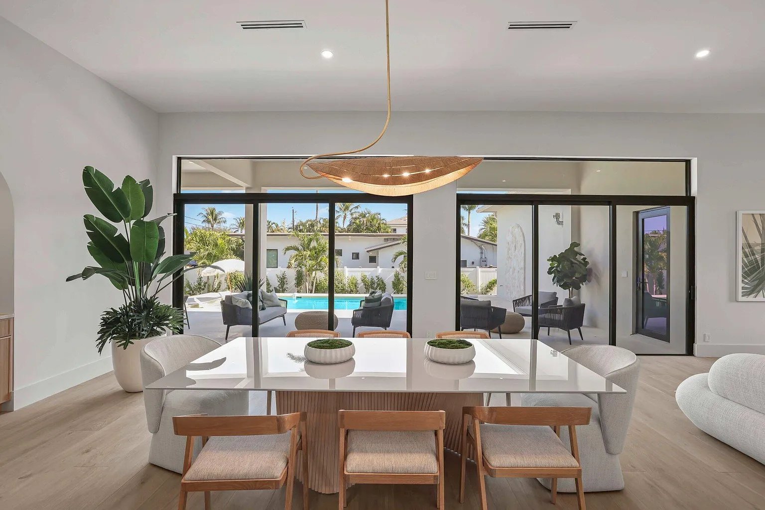 Indoor-outdoor dining flowing to the pool — custom build by Acassa Construction
