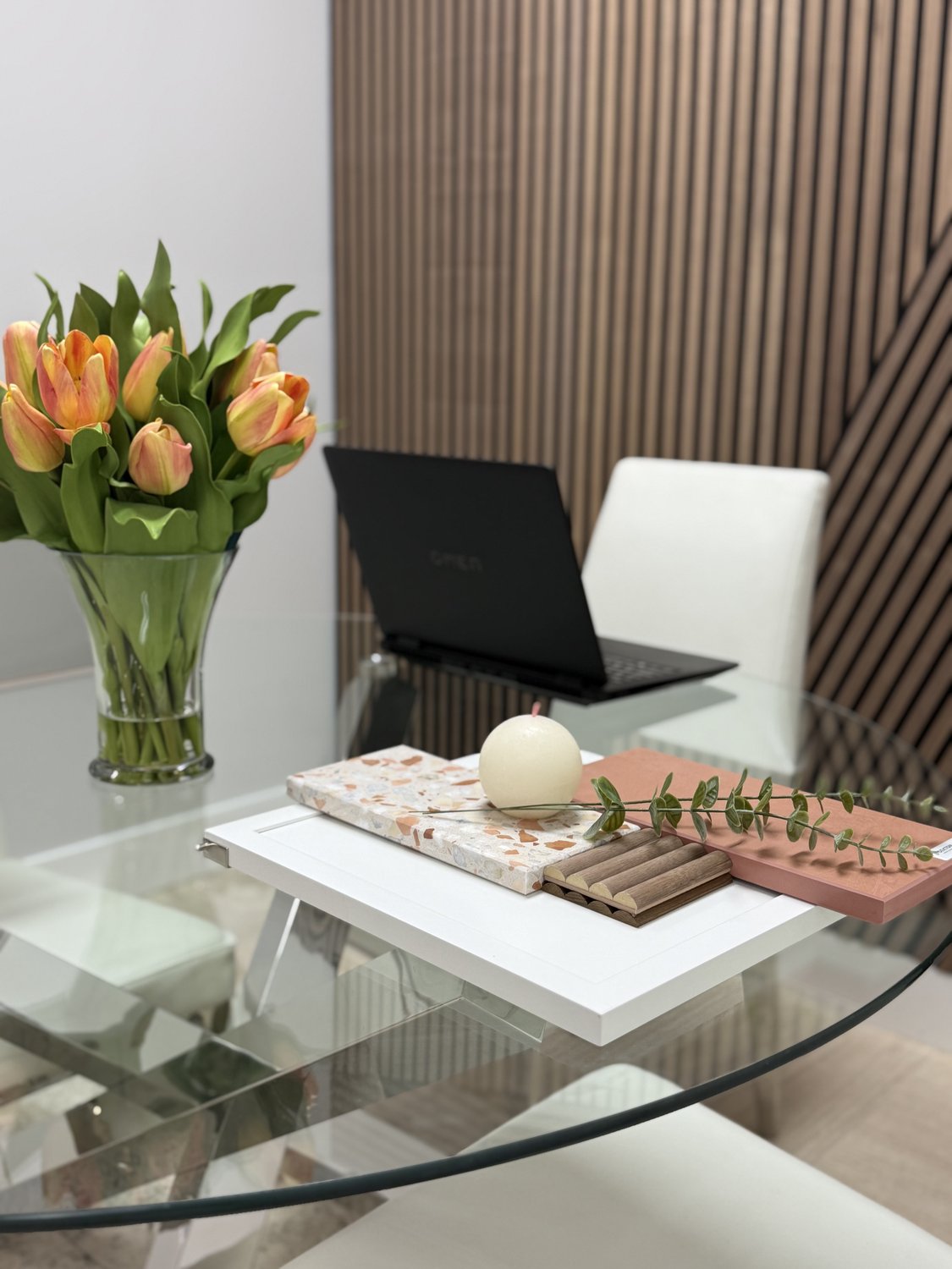 Consultation table in the showroom set with fresh tulips, a stone sample, and a swatch tray ready for a client meeting
