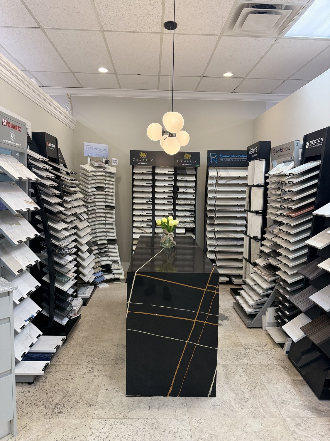 Stone-slab sample displays in the Acassa showroom, dozens of marble, granite, and quartzite options on vertical racks